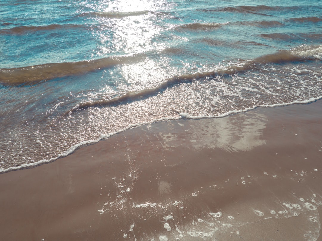Surfing in Morocco in summer - empty beginner beach with small gentle whitewater waves and warm light on the Atlantic coast near Agadir
