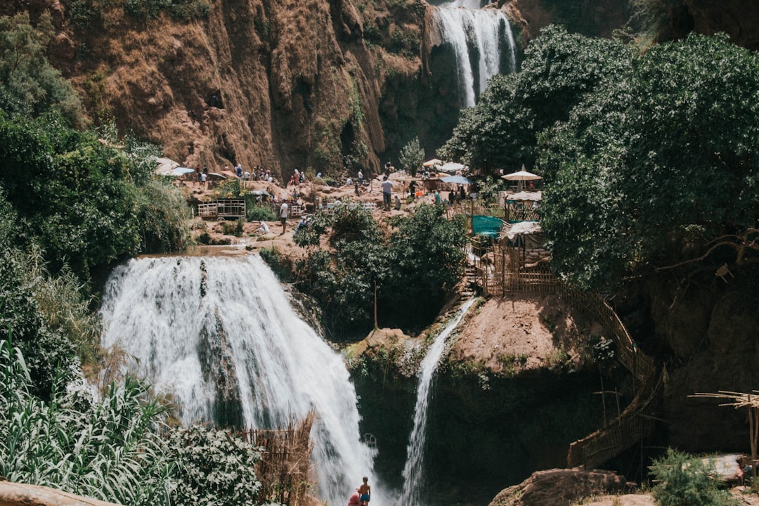 Ouzoud Waterfalls near Marrakech — 110-metre multi-tier cascade with rainbow in the spray, green Middle Atlas gorge
