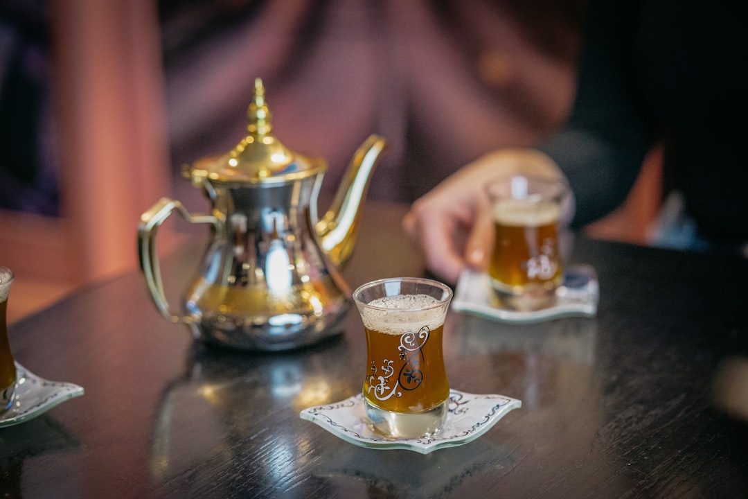 Pourboire dans les restaurants marocains — un serveur marocain versant du thé à la menthe d'une hauteur dans un verre