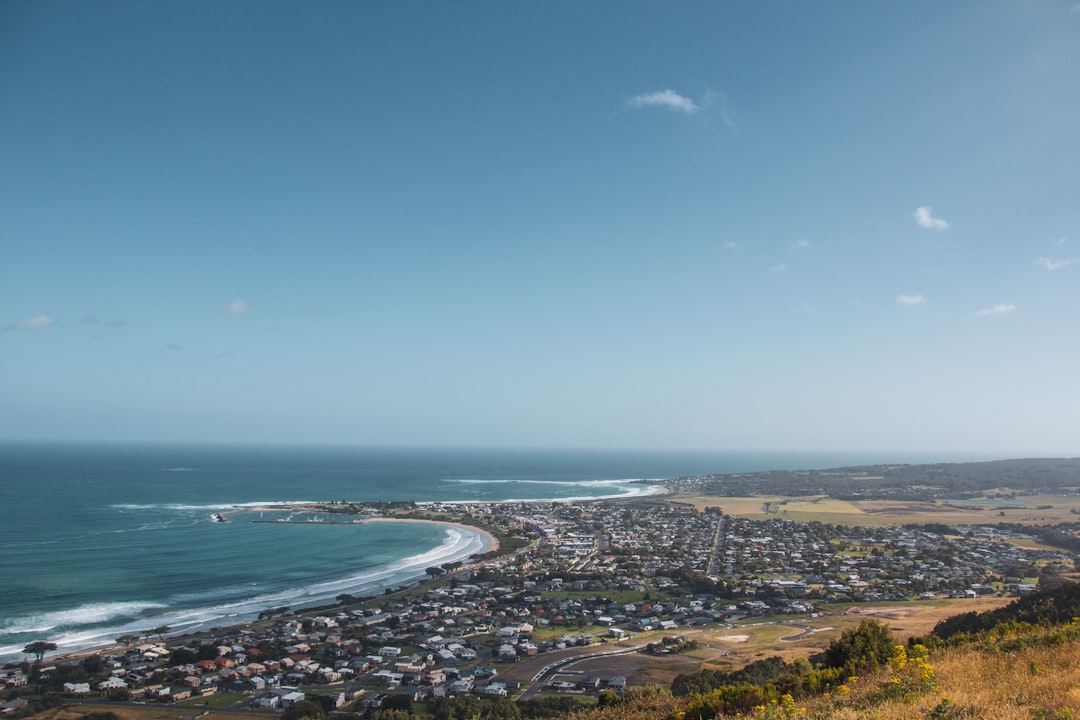 Taghazout surf village in Morocco — whitewashed rooftops above the bay with surfboards and surfers